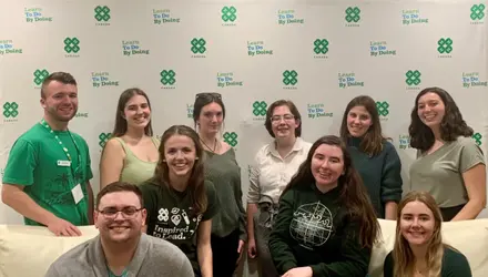 10 Youth Advisory Committee members posed and smiling in front of 4-H Canada backdrop